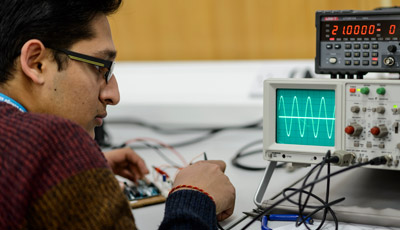 Student looking at an oscilloscope
